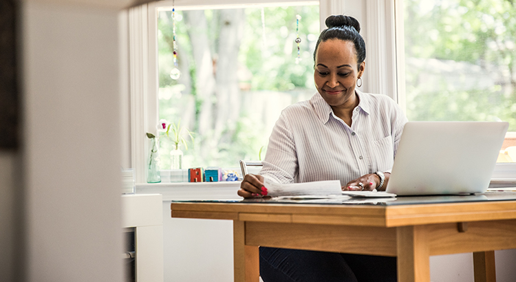 Woman working on laptop in kitchen